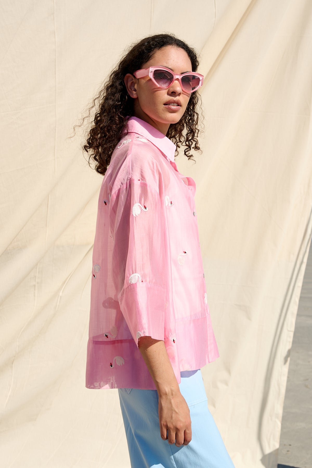 Pink oversized button-up shirt with embroidered swans and wide cuffs
