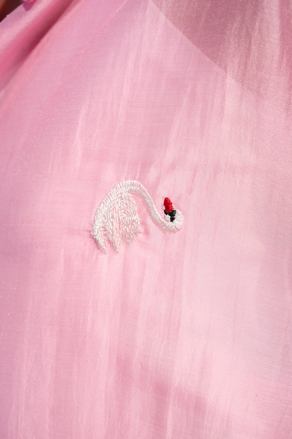 Pink oversized button-up shirt with embroidered swans and wide cuffs