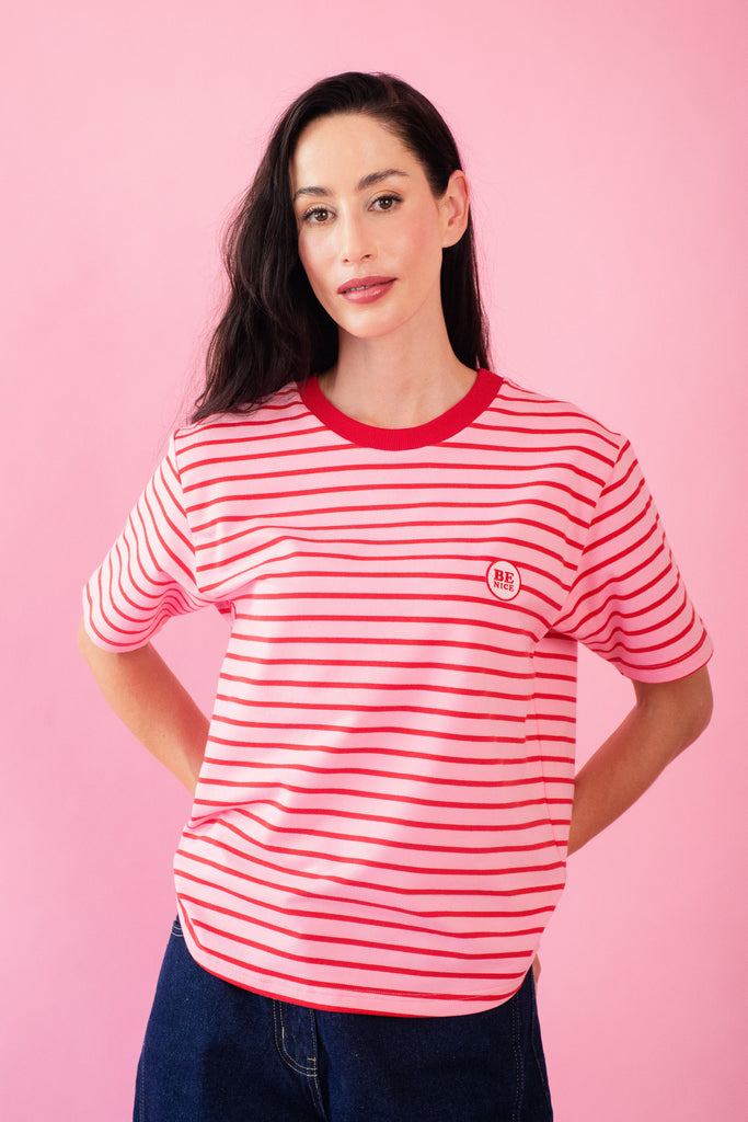 Model wearing pink and red stripe tee with be nice embroidery