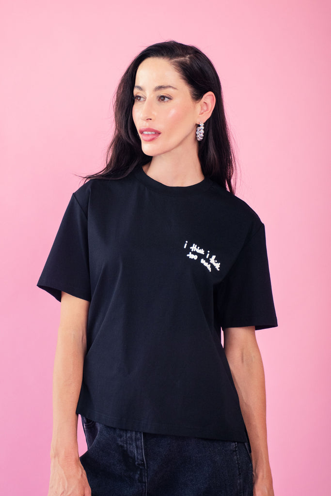 Model wearing black tee with think too much rubber detail