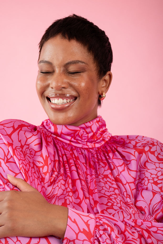 Model wearing pink and red, floral print dress