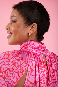 Model wearing pink and red, floral print dress