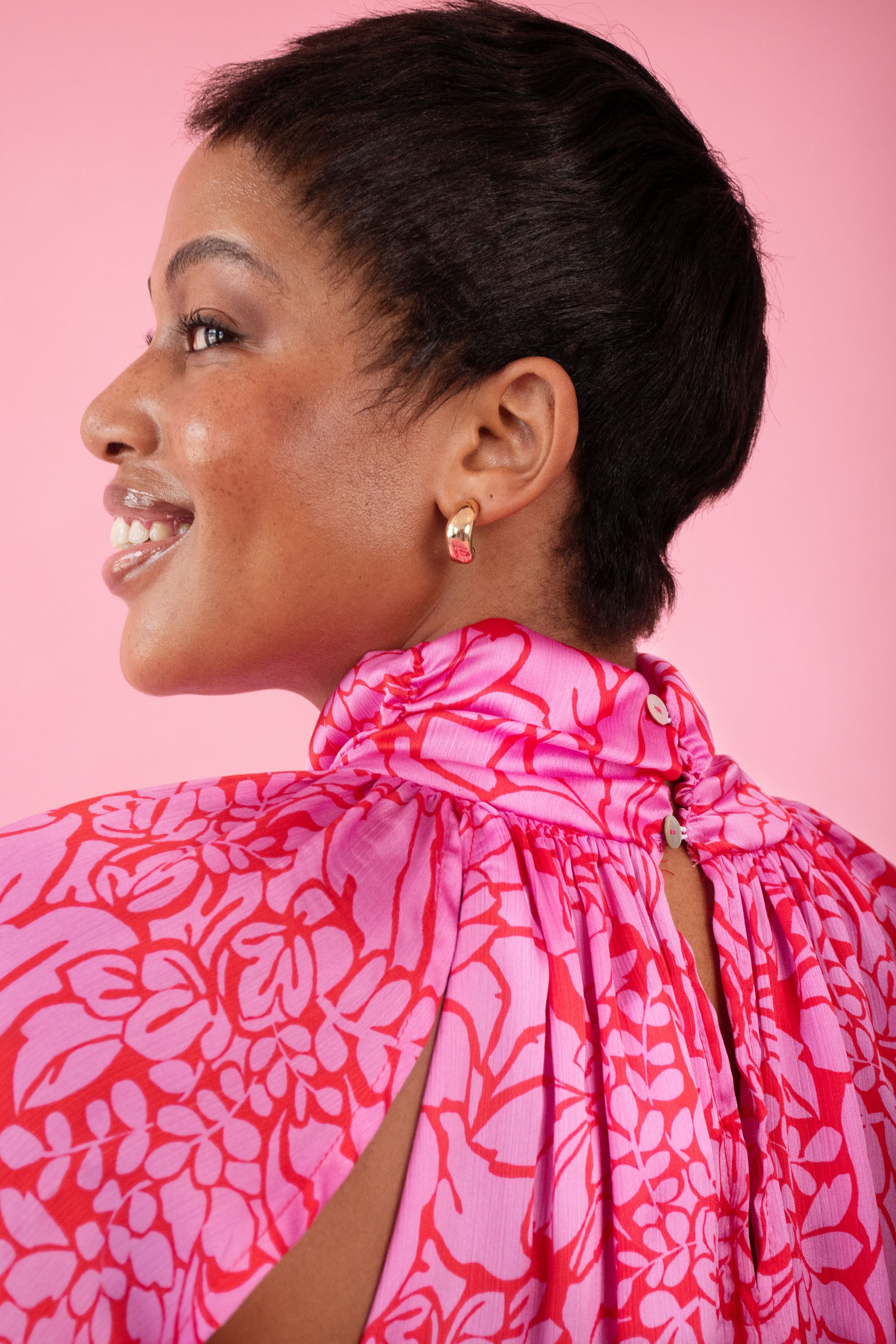 Model wearing pink and red, floral print dress