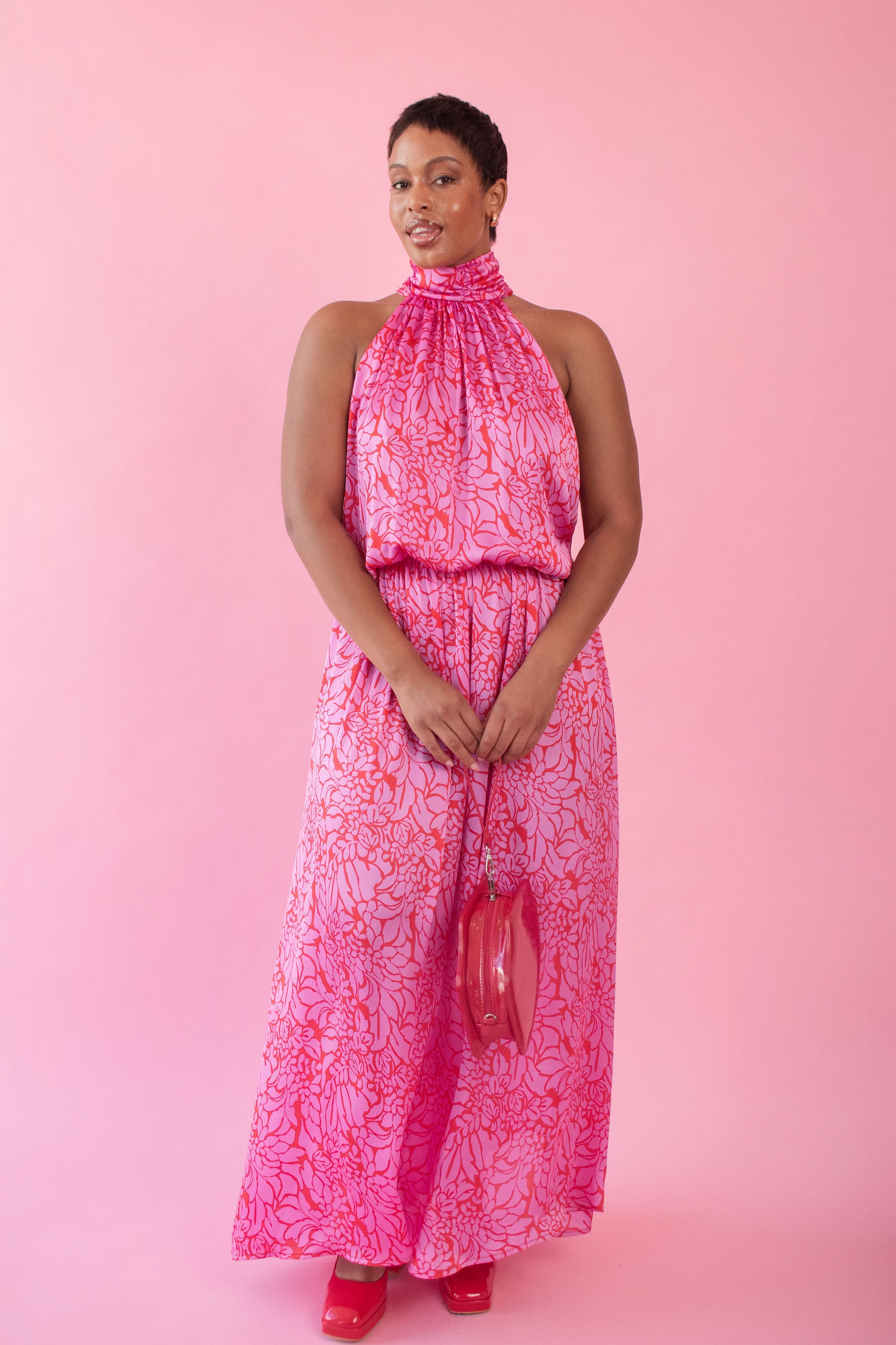 Model wearing pink and red, floral print dress