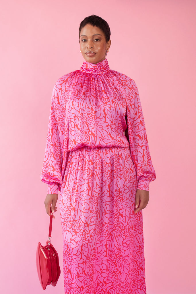 Model wearing pink and red, floral print dress