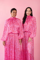 Models wearing pink and red, floral print dress