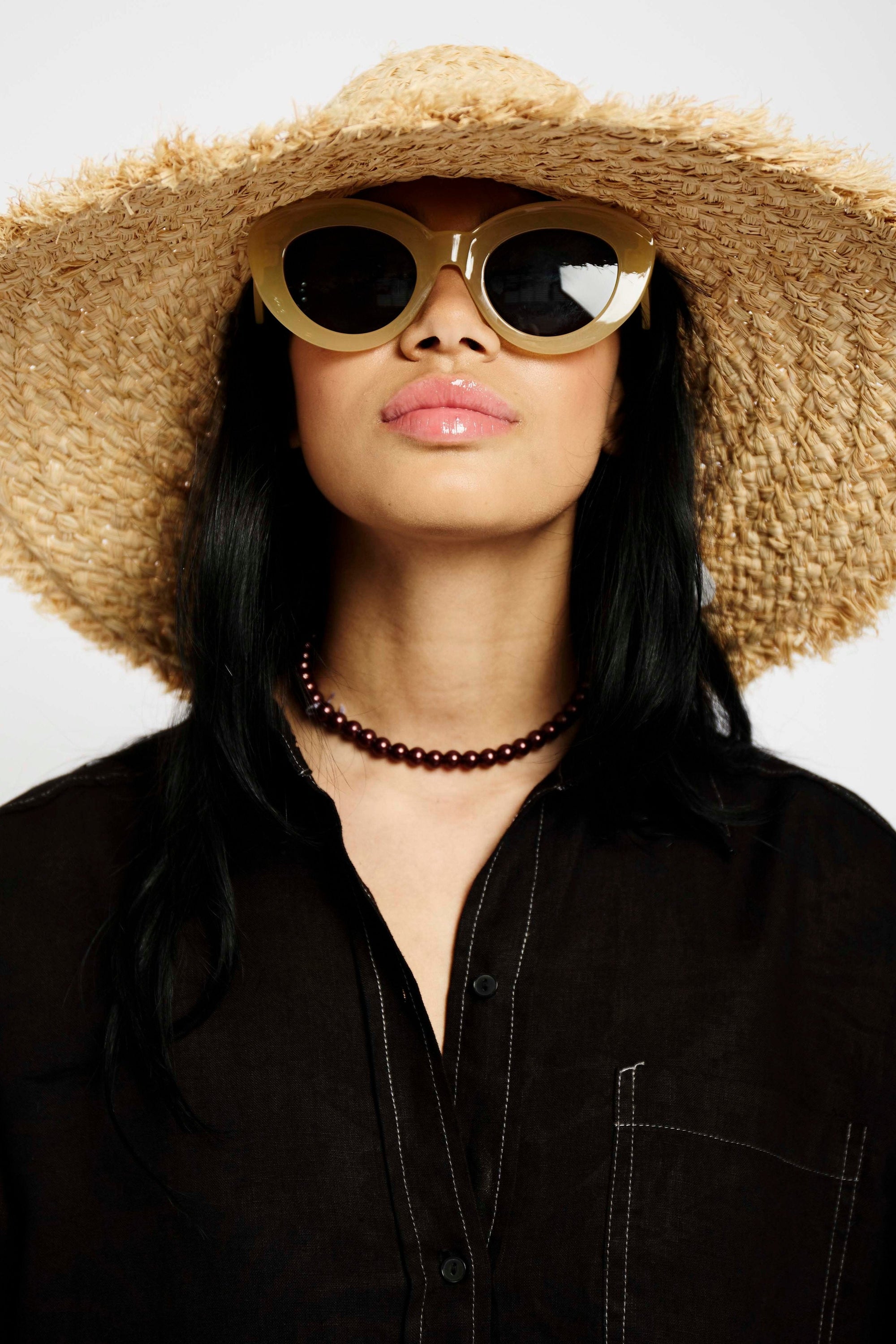 Model wearing a Big Straw Hat that is straw coloured