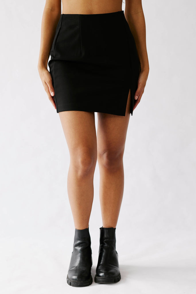 Model wearing black mini skirt and boots.