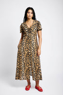 Model wearing an animal print dress with big collar and red shoes