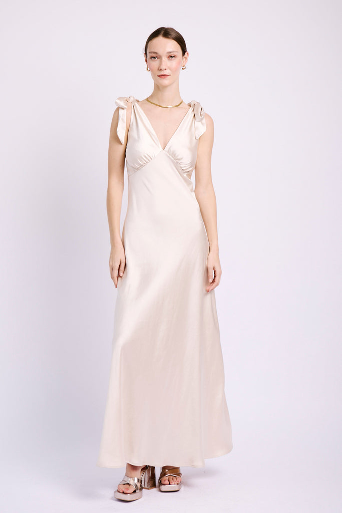 Model wearing champagne coloured dress with tie strap. for bridesmaid outfit