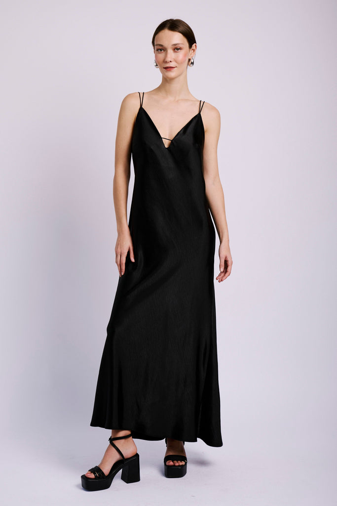 Model wearing black slip dress with shock cord