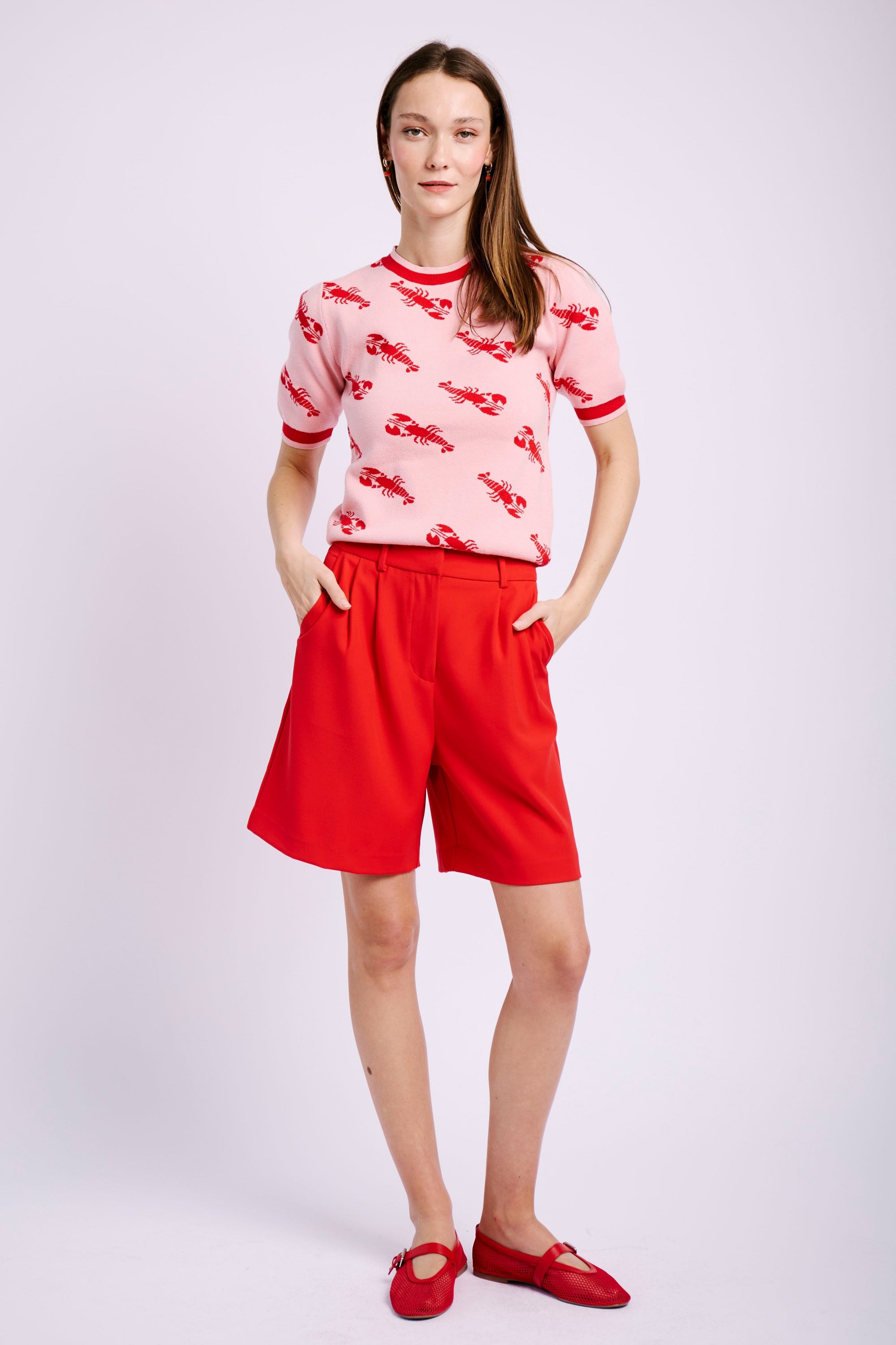 MODEL WEARING RED SHORTS AND PINK AND RED KNIT WITH LOBSTERS ON