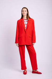 Model wearing red suit and cherry jumper