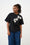 Model is wearing a black T shirt with white floral applique