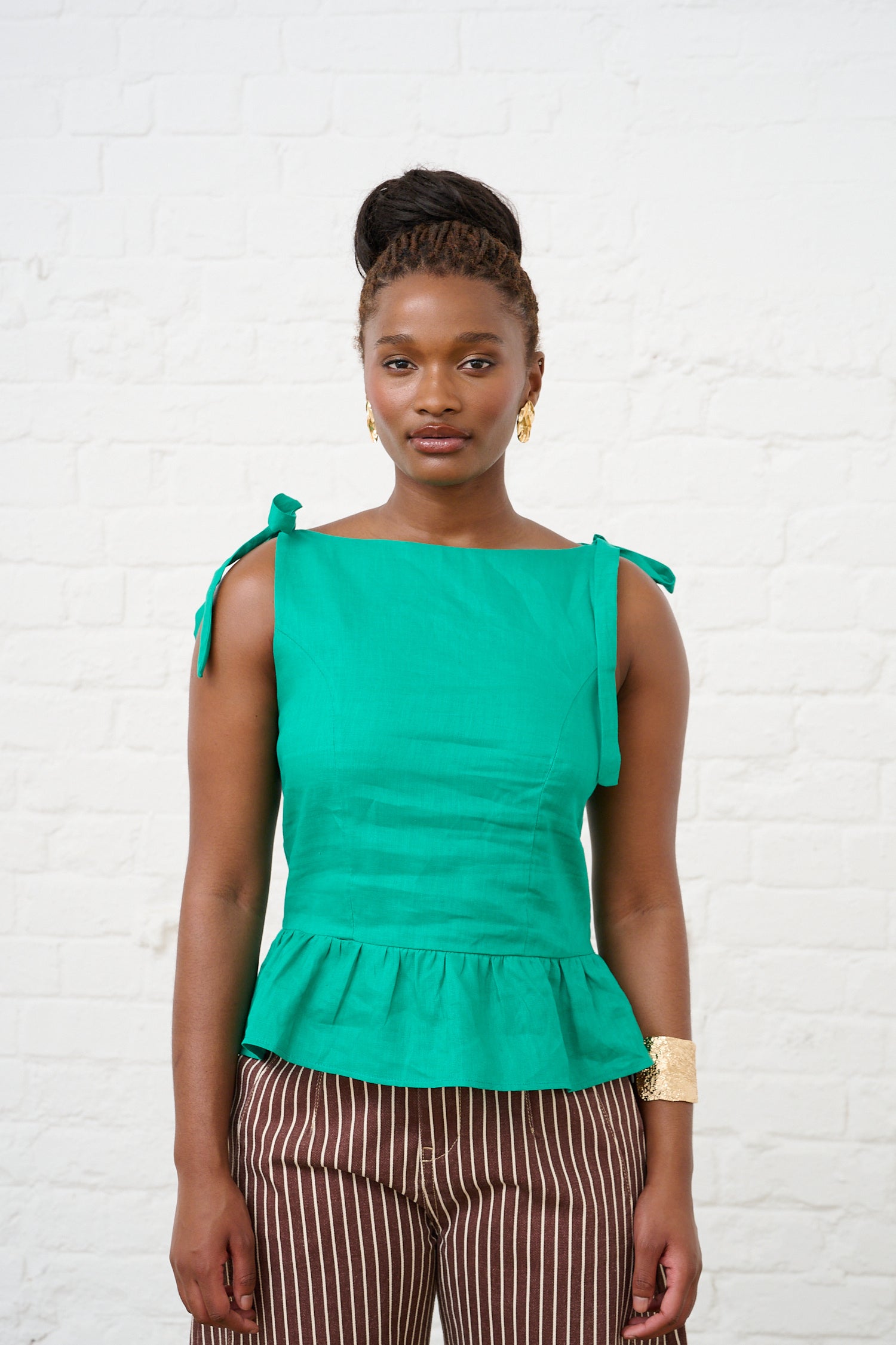 Model is wearing a green peplum top 