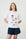 Model is wearing a white T-Shirt with beach scene on it and black shorts 