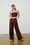 Model is wearing a linen brown crop top with brown linen wide leg pants and brown sandals by Me&B