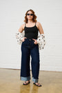 Model is wearing a black cami, turn up jeans and sandals