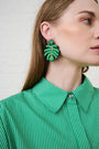 Model is wearing green and yellow beaded earrings and a green shirt