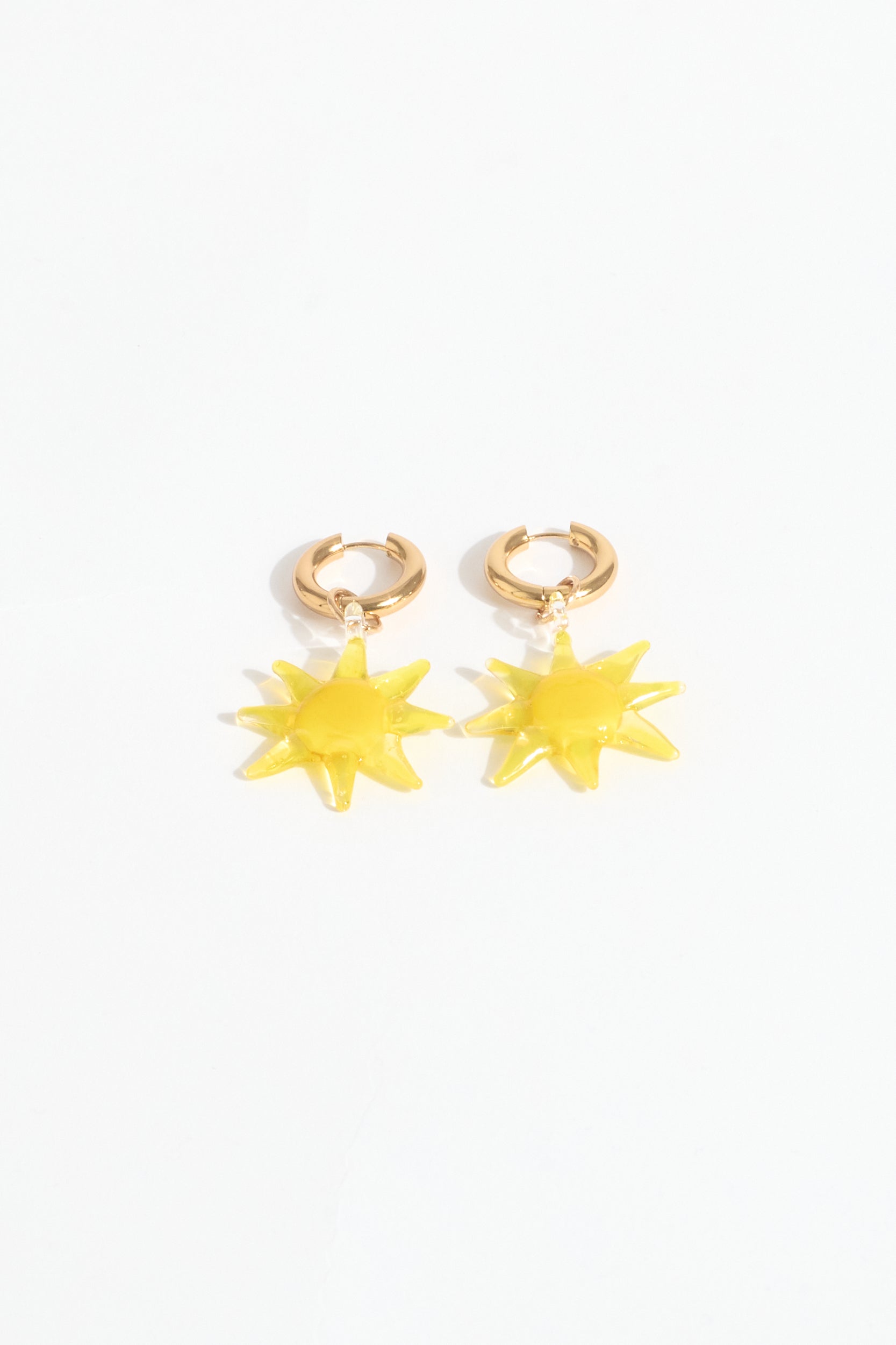 Gold hoop earrings with yellow star-shaped charms on a white background