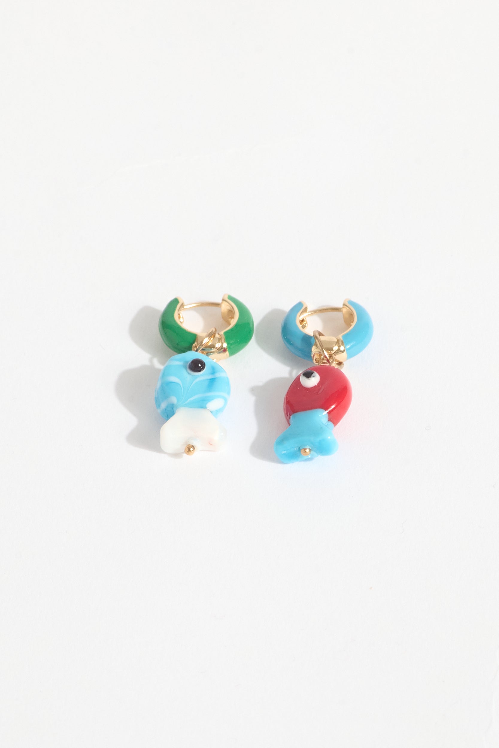 Colorful fish-shaped earrings on a white background