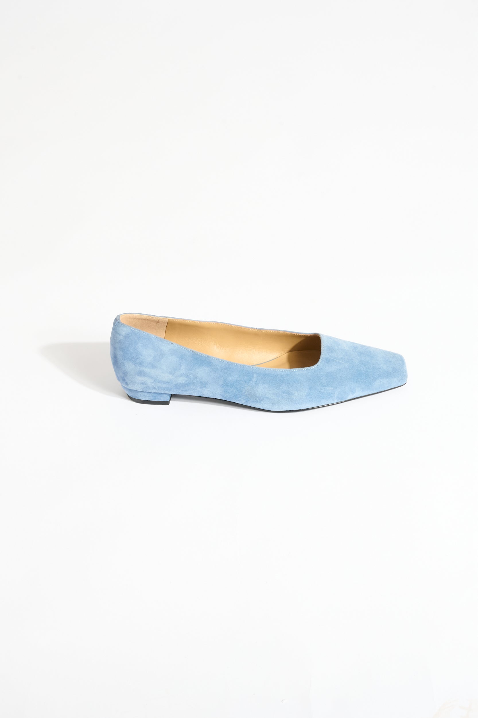 Light blue suede flat shoe on a white background