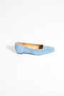 Light blue suede flat shoe on a white background