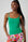 Model is wearing a green cami top with floral shorts