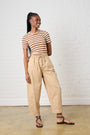 Model is waring brown barrel leg ants with a brown and white striped knit short sleeve top 