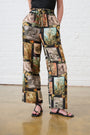 Model is wearing a gallery printed pants with a black Cami and Black Sandals