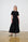 Model is wearing a black short sleeve combo dress with white and black ballet flats 