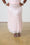 Model is wearing a light pink sequin skirt and silver sandals