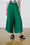 Model is wearing linen wide leg forrest green pants with black sandals