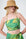Model is wearing a green and yellow bandeue top with a straw hat 