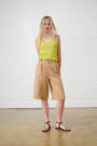 Model is wearing a lime vest with brown bermuda shorts and sandals