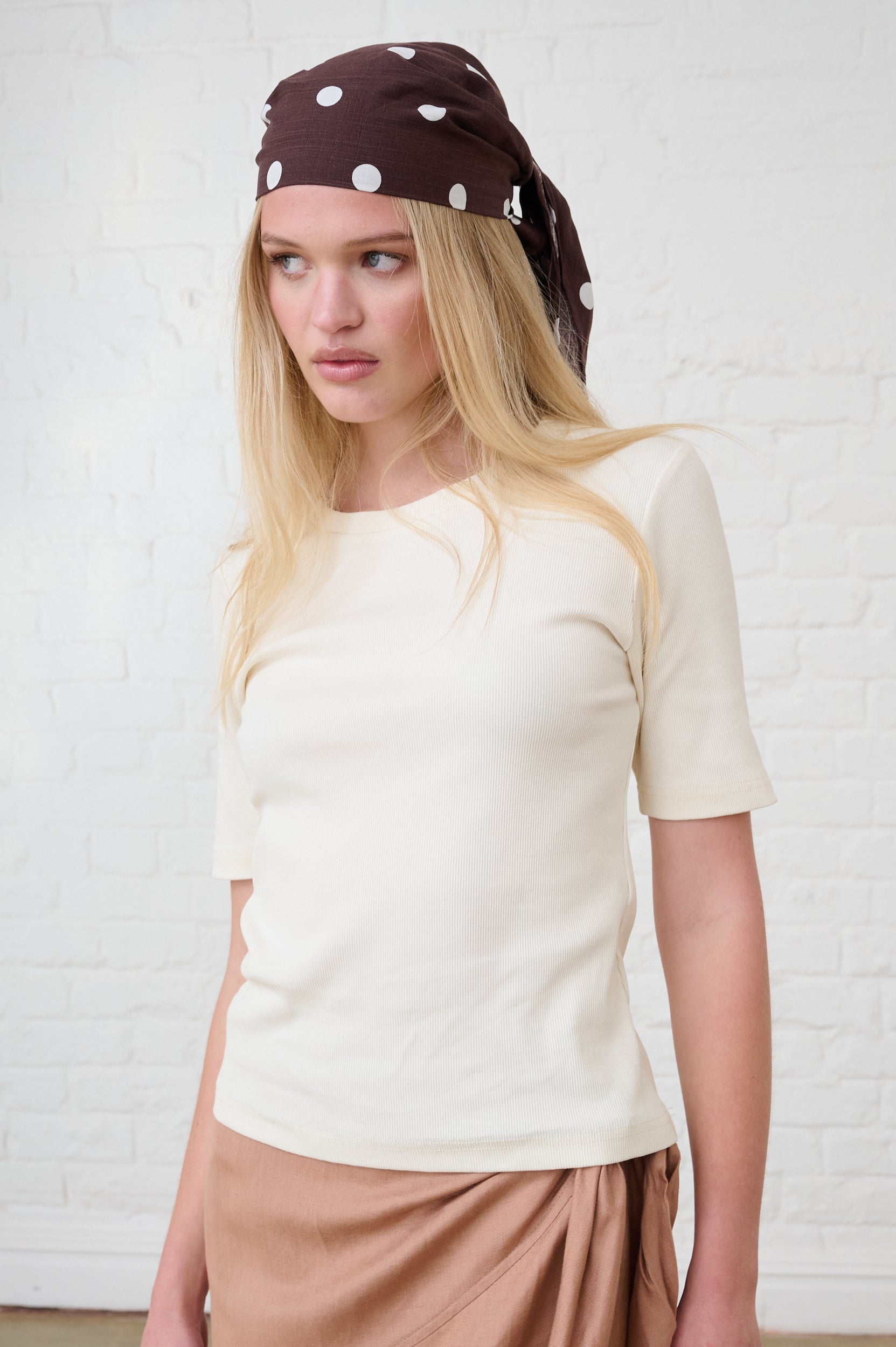 Model is wearing a short sleeve cream ribbed top with a chocolate brown spot head band 