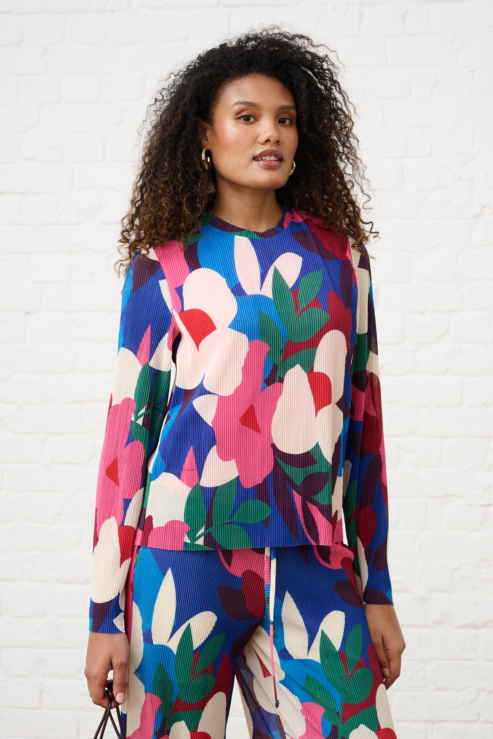 Model is wearing a long sleeve floral multi top with matching bottoms and silver earrings 