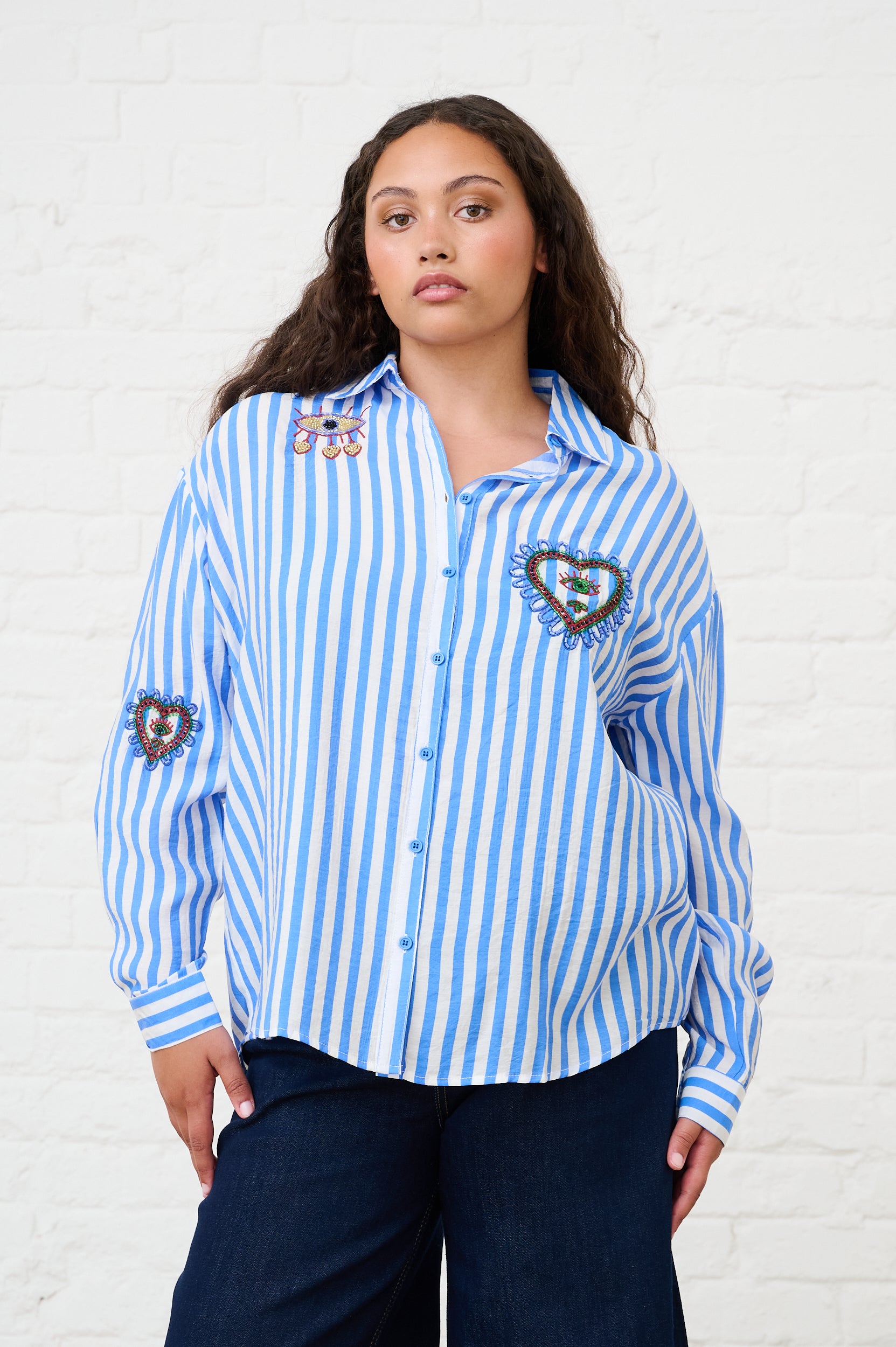 Model is wearing a blue and white striped beaded shirt
