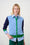 Model is wearing a blue colour block cardigan with green and navy gingham pants 