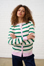 Model is wearing a pastel striped cardigan with dark wash jeans 