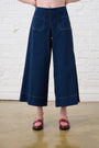 Model is wearing navy bengaline stretch cropped pants with pink loafers