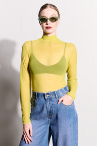 Model is wearing a long sleeve polo neck mesh top in yellow with blue denim jeans and sunglasses