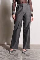 Model is wearing grey pants, a black mesh top and silver shoes