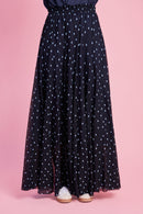Model is wearing a blue spot mesh skirt with white sneakers 