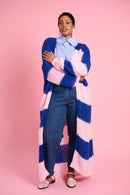 Model is wearing blue and pink striped cardigan with blue jeans and pink shoes 