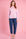 Model is wearing a pink stripe peter pan shirt with denim jeans 