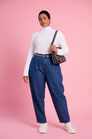 Model wearing a long sleeve polo with blue jeans and white sneakers