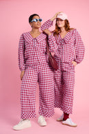 Models are wearing a burgundy and blue check set with white sneakers 
