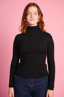 Model is wearing a black long sleeve polo with dark denim jeans 