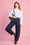 Model is wearing white peter pan collar with denim barrel jeans , a studded bag, belt and shoes